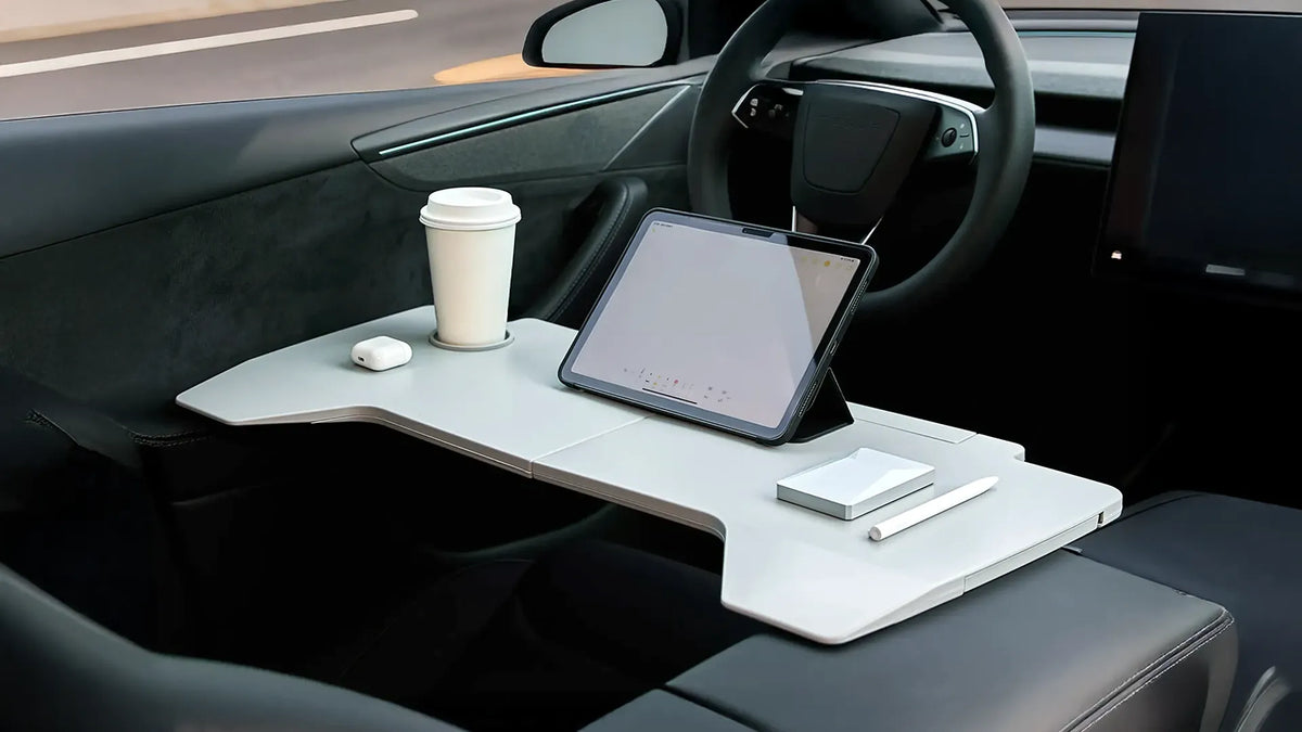 テスラの車内でテーブルにタブレットとコーヒーを置いて使う様子
